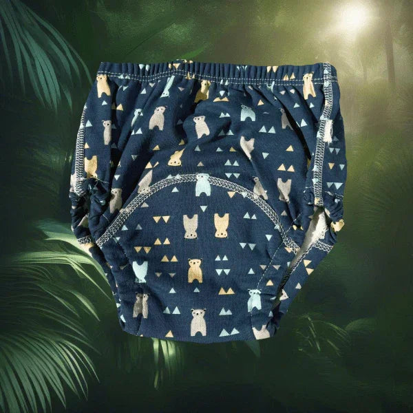 O pereche de chiloței de antrenament pentru copii, de culoare bleumarin cu imprimeu vesel cu ursuleți panda și forme geometrice, prezentați pe un fundal decorativ de inspirație tropicală cu frunze de palmier, ideali pentru o tranziție confortabilă de la scutece